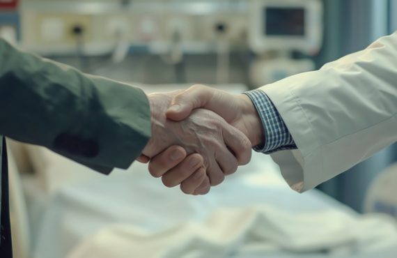 Close-up of a handshake between a doctor and a patient in a hospital setting