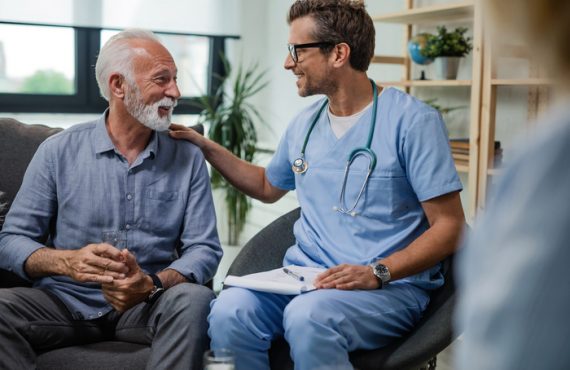 Happy doctor talking to senior male patient