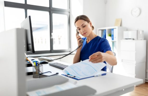 nurse with computer calling on phone at hospital