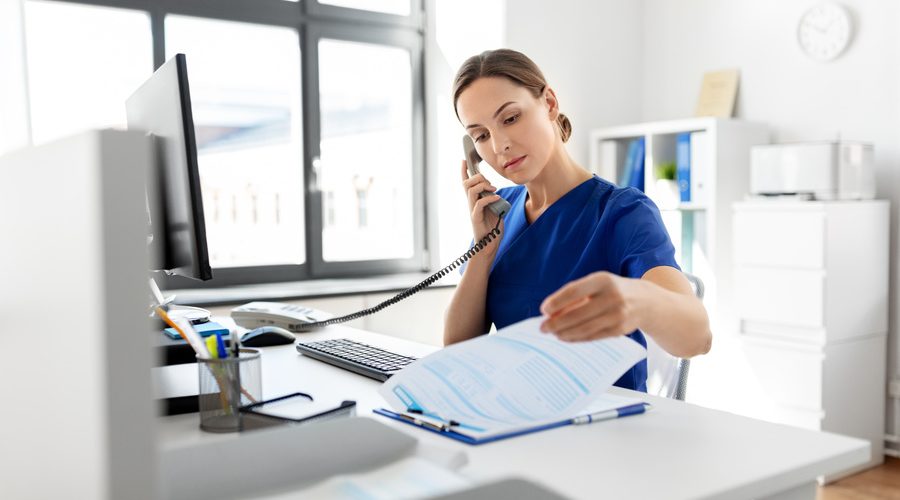 nurse with computer calling on phone at hospital